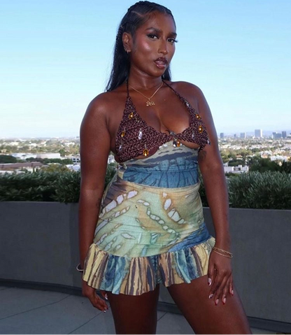 Woman wearing a patterned top and skirt with a cityscape in the background